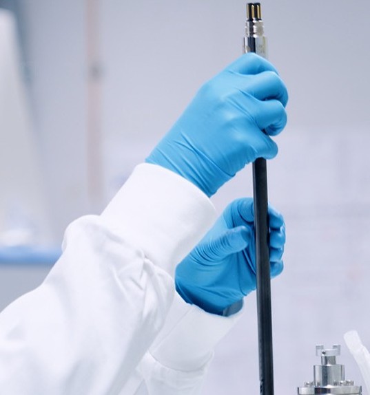 Hände in medizinischen Handschuhen halten GlucoSense von Hamilton